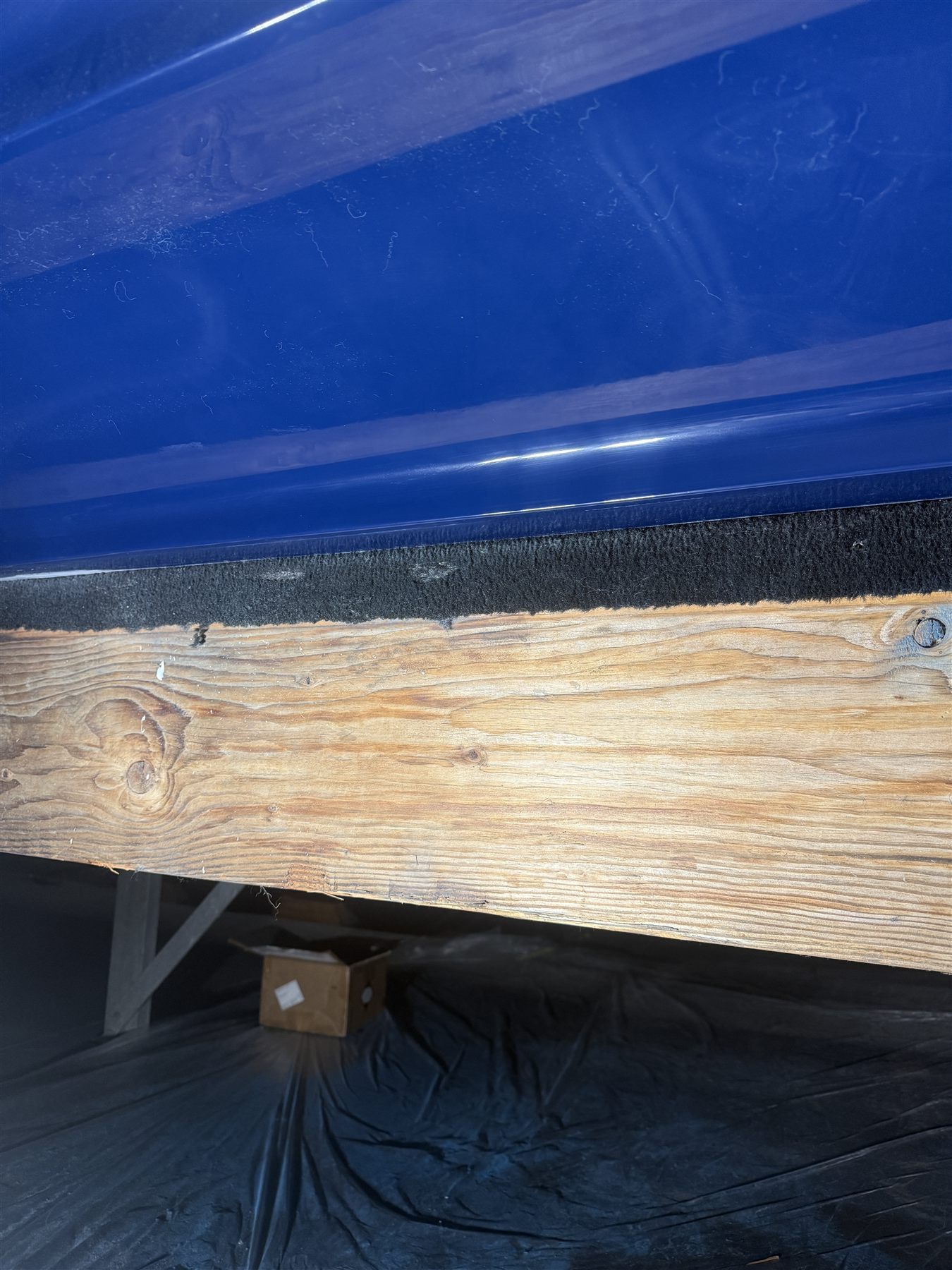 Wider view of damage on a dark-blue hull